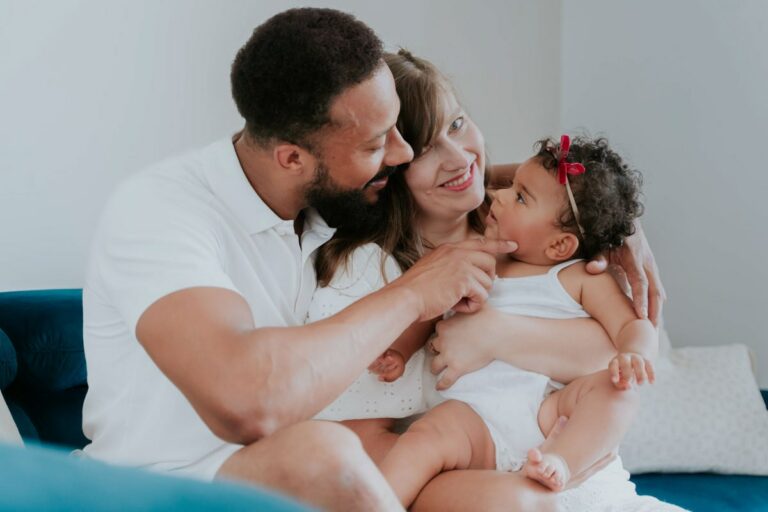 famille lors d'une séance photo à paris, papa qui regarde son bébé dans les bras de sa maman